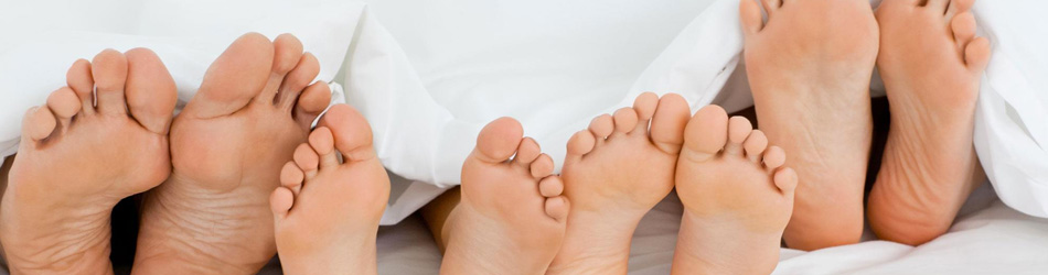 Blote voeten onder een dekbed